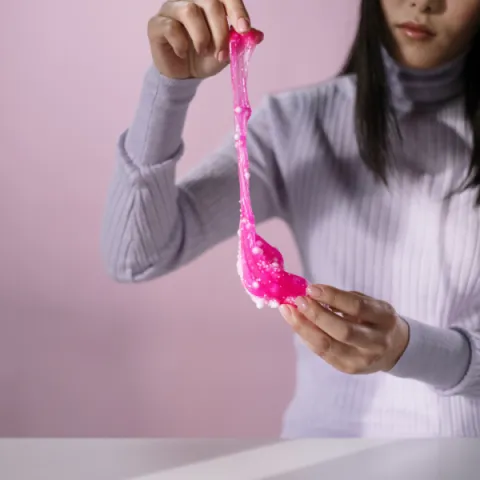 a woman holding pink slime